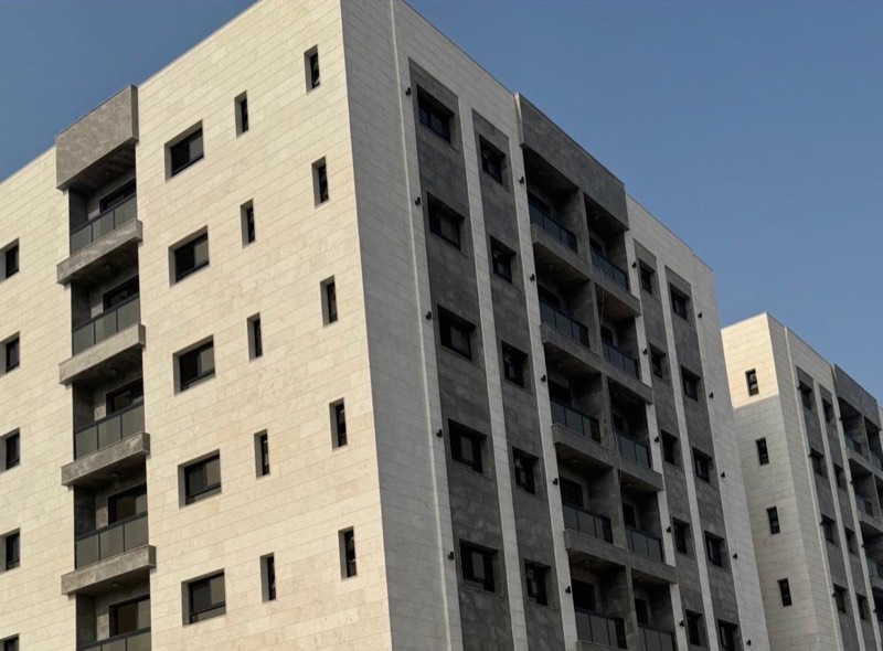 Two completed seven-storey residential buildings with stone-clad facades