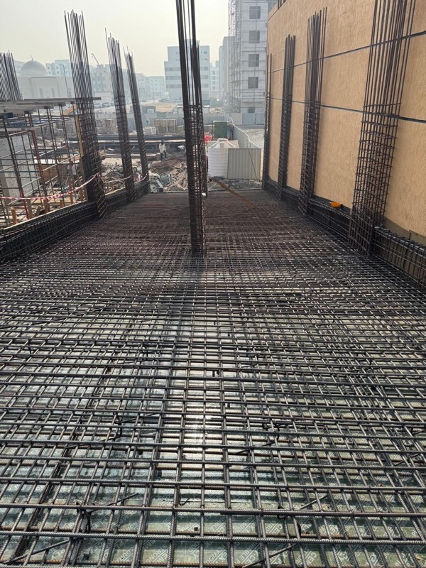 Column starter bars standing on a two-layer raft reinforcement mesh